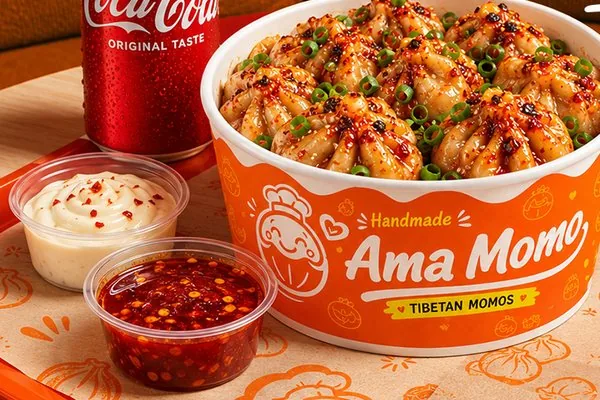 Ama Combo tray with steamed momo, sauces and Coca-Cola
